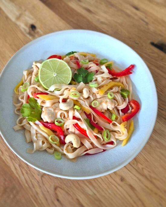 Glasnudelsalat mit Mango, Paprika und Hähnchen wird mit Frühlingszwiebeln, Koriander, Cashewkernen und Limette frisch und süss-scharf angerichtet.