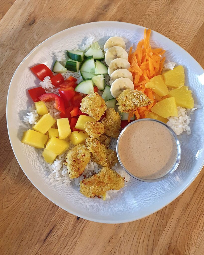 Sommerliche Bowl mit paniertem Hähnchen und Erdnuss-Sauce