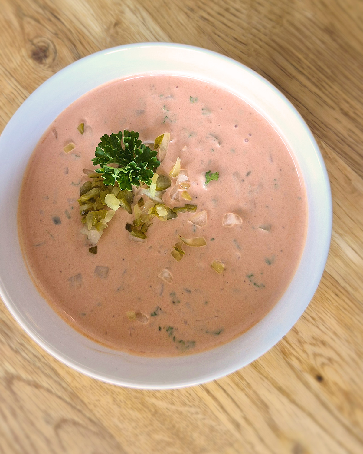 In die cremige leicht rosa Burgersauce kommen Quark, Mayonnaise, Ketchup, Gewürzgurken, Zwiebeln, Worcestershiresauce und Petersilie.
